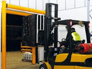 carretilla elevadora que pasa por la puerta del almacén mostrando la altura del mástil y el espacio libre de la puerta